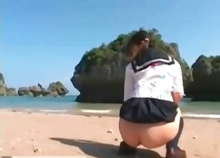 Outdoors shitting on the beach with an Asian teen
