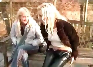 Two girls sitting on the bench and only one is pissing