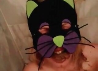 Wearing a kitty mask and playing with lots of poop